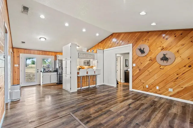 a view of a big room with wooden floor and windows