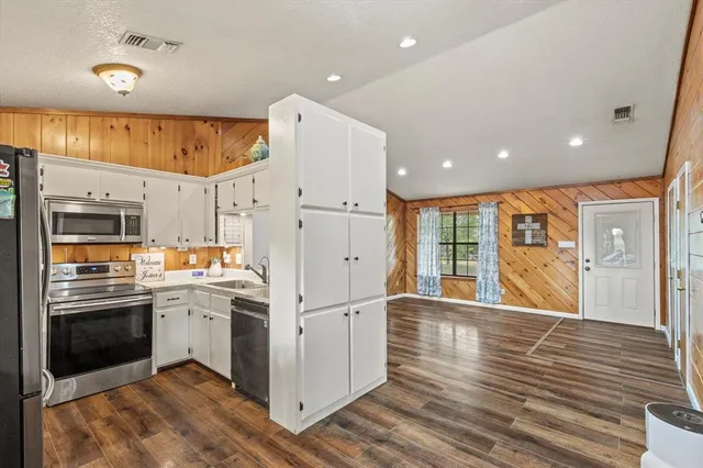 a kitchen with stainless steel appliances granite countertop a refrigerator a sink and a stove