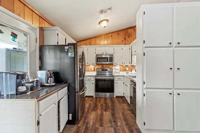 a kitchen with white cabinets and stainless steel appliances