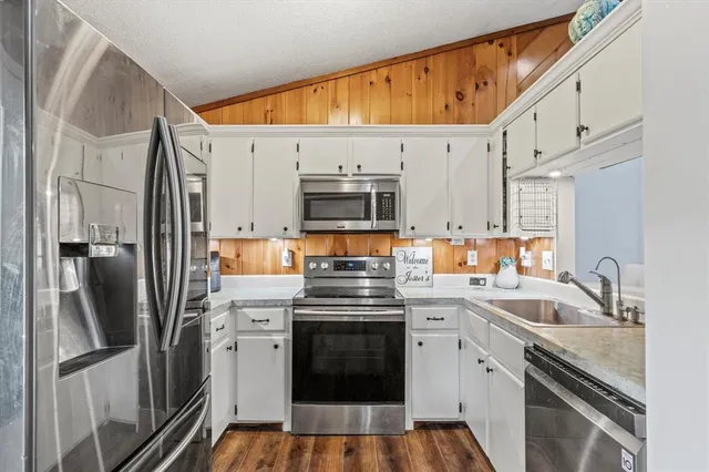 a kitchen with stainless steel appliances a stove sink and refrigerator