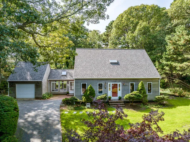 a front view of a house with a yard and outdoor seating
