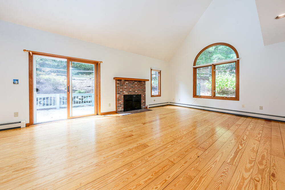 34 Ridgewood Road Orleans, MA 02653 - Photo 14 of 41 a view of an empty room with wooden floor fireplace and a window