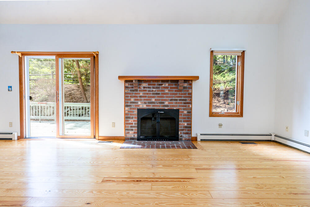 34 Ridgewood Road Orleans, MA 02653 - Photo 15 of 41 a living room with a fireplace and a floor to ceiling window