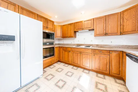 a kitchen with granite countertop a sink stainless steel appliances and cabinets