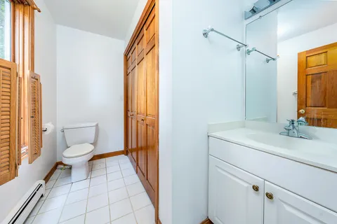 a bathroom with a sink a toilet and a large mirror
