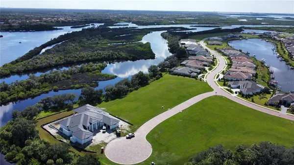 an aerial view of a house with a garden and lake view