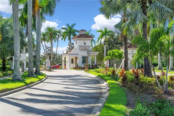 a front view of a house with fountain and potted plants