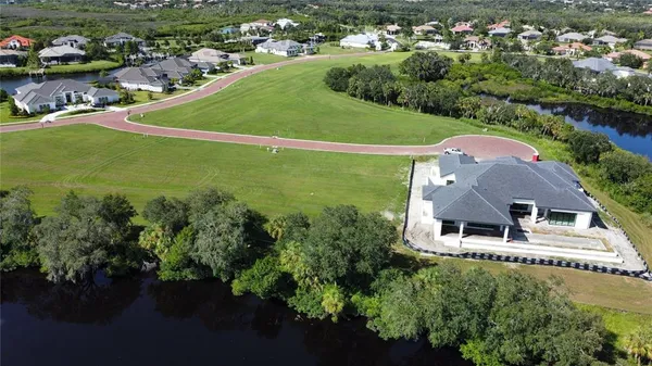 an aerial view of a house with a garden and lake view