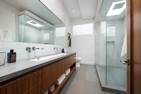 a spacious bathroom with a double vanity sink and mirror