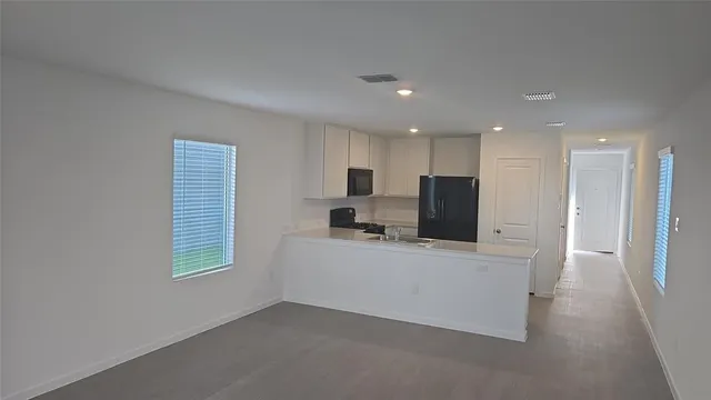 a living room with stainless steel appliances kitchen island furniture and a window