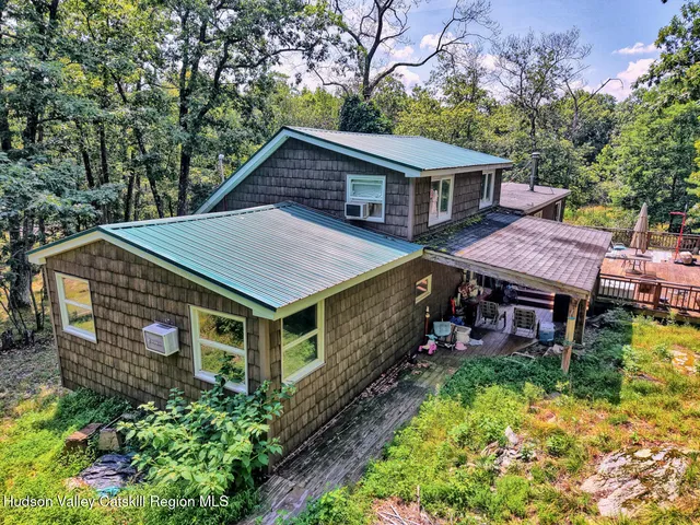 a view of a house with a big yard plants and large trees