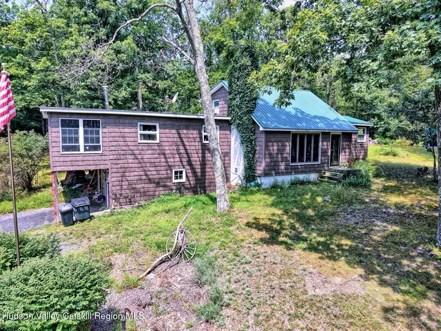 a view of a house with a lush green forest