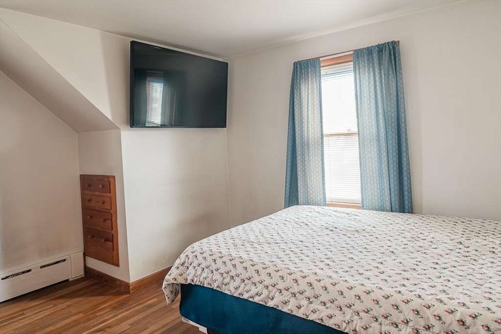 7 Park Street Hamilton, MA 01982 - Photo 23 of 36 a bedroom with a bed and a flat screen tv