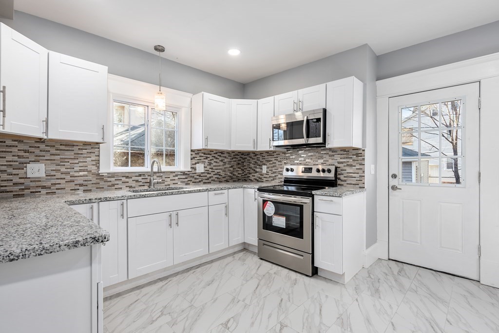 14 Burton Street Springfield, MA 01108 - Photo 19 of 35 a kitchen with granite countertop a stove a sink and a microwave