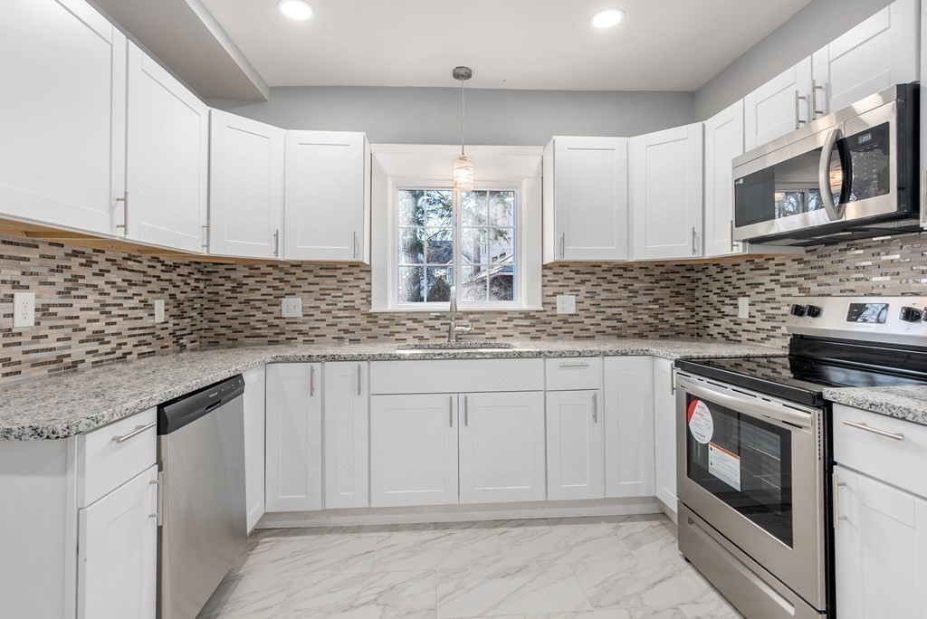 14 Burton Street Springfield, MA 01108 - Photo 20 of 35 a kitchen with stainless steel appliances granite countertop white cabinets sink and window
