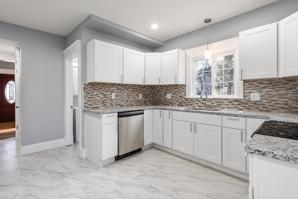 14 Burton Street Springfield, MA 01108 - Photo 21 of 35 a kitchen with granite countertop white cabinets sink and window