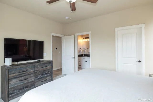 a spacious bedroom with a bed and a flat screen tv