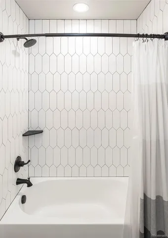 a bathroom with a bathtub and a shower curtain