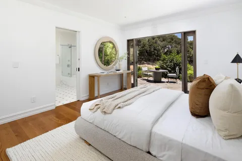 a bedroom with a bed window and potted plant