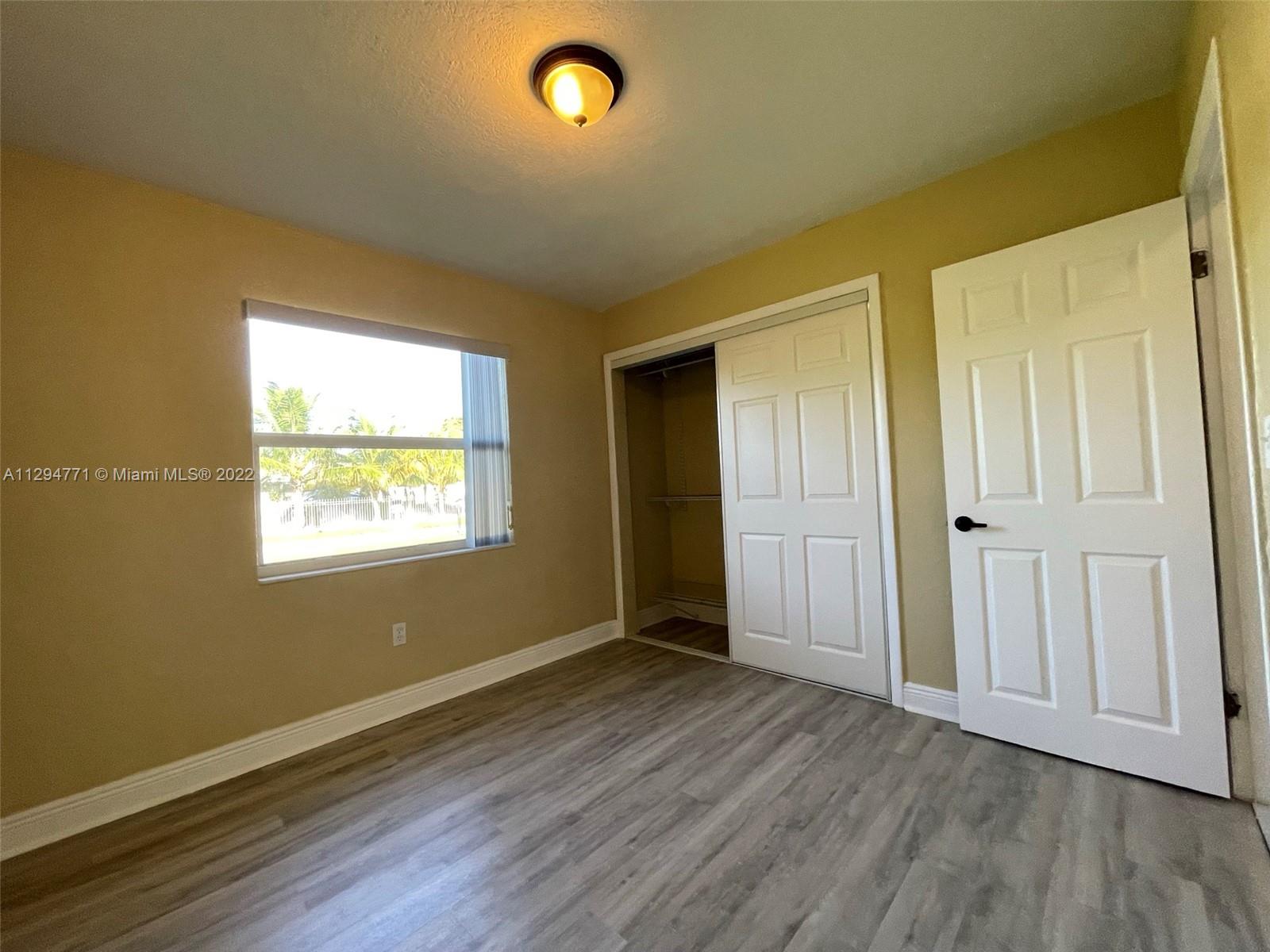 14515 Southwest 105th Court Miami, FL 33176 - Photo 12 of 30 an empty room with wooden floor and windows