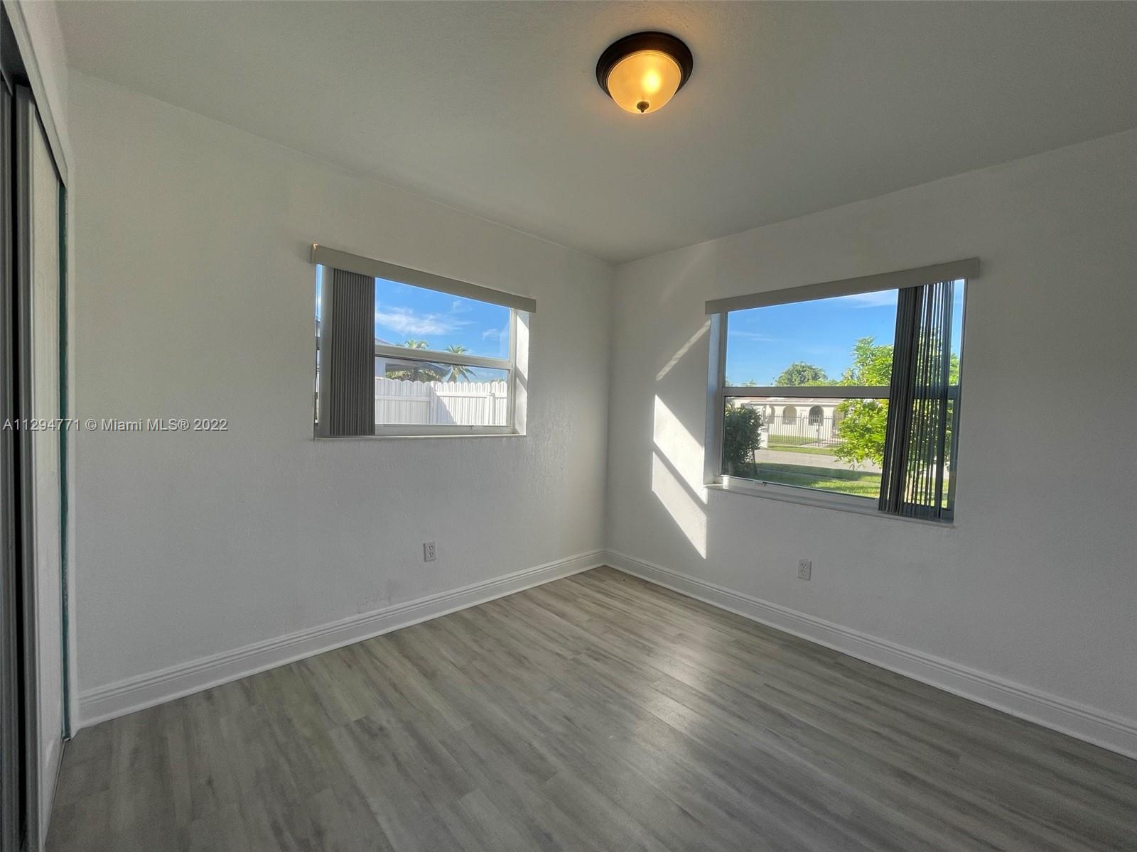 14515 Southwest 105th Court Miami, FL 33176 - Photo 14 of 30 an empty room with wooden floor and windows
