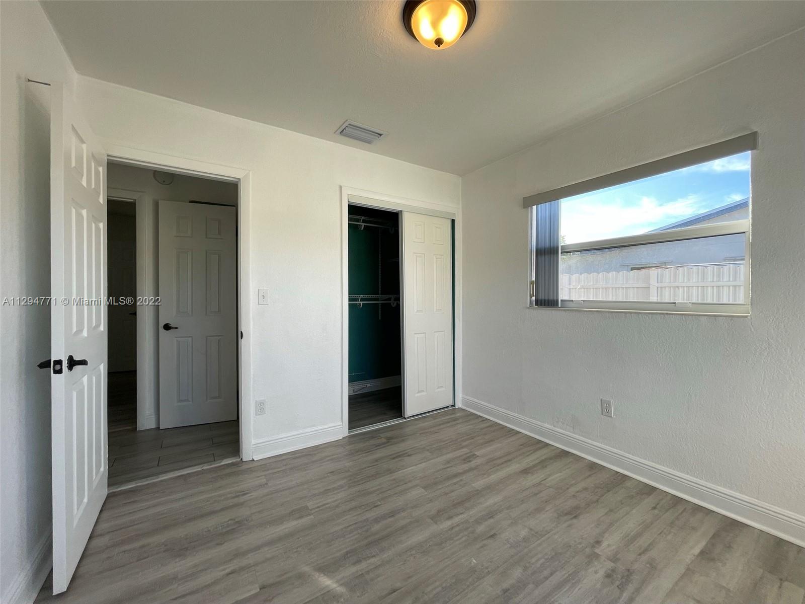 14515 Southwest 105th Court Miami, FL 33176 - Photo 15 of 30 an empty room with wooden floor and windows