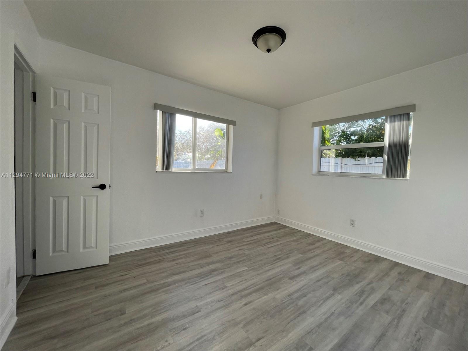14515 Southwest 105th Court Miami, FL 33176 - Photo 17 of 30 an empty room with wooden floor and windows