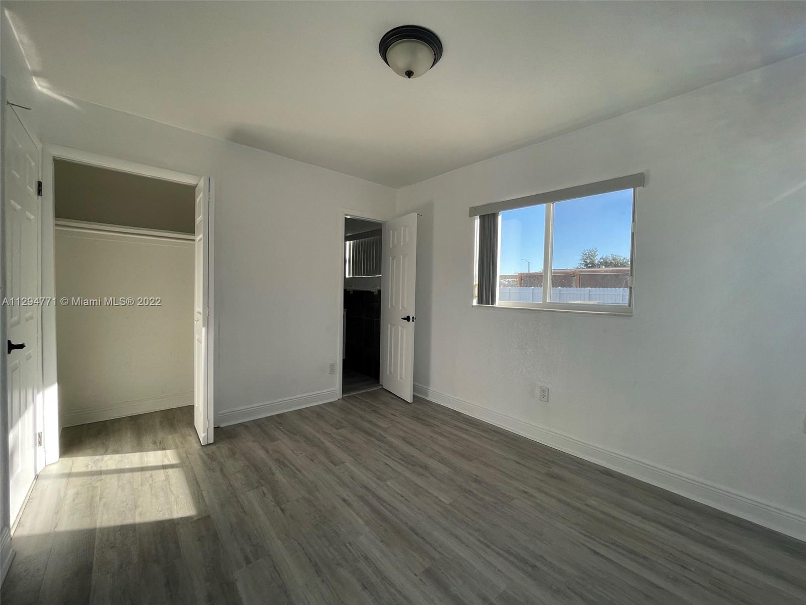 14515 Southwest 105th Court Miami, FL 33176 - Photo 18 of 30 an empty room with wooden floor and windows