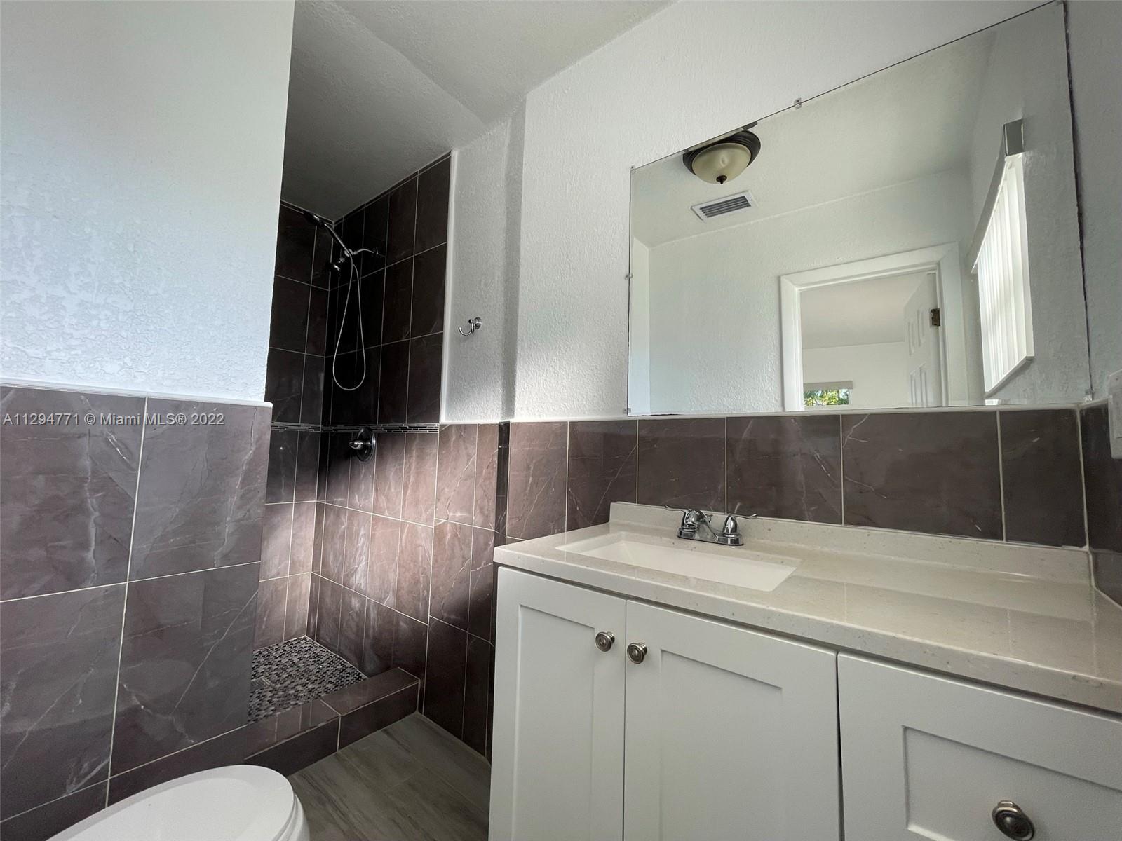 14515 Southwest 105th Court Miami, FL 33176 - Photo 19 of 30 a bathroom with a sink a toilet and a mirror