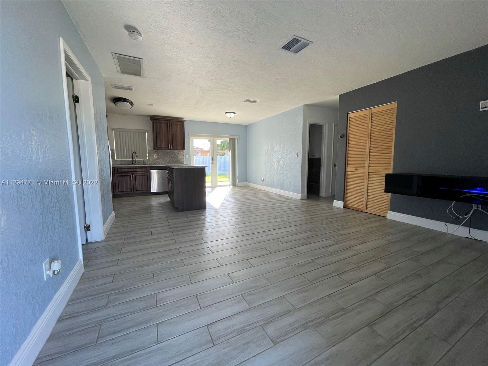 14515 Southwest 105th Court Miami, FL 33176 - Photo 3 of 30 a view of a kitchen with a sink and a refrigerator