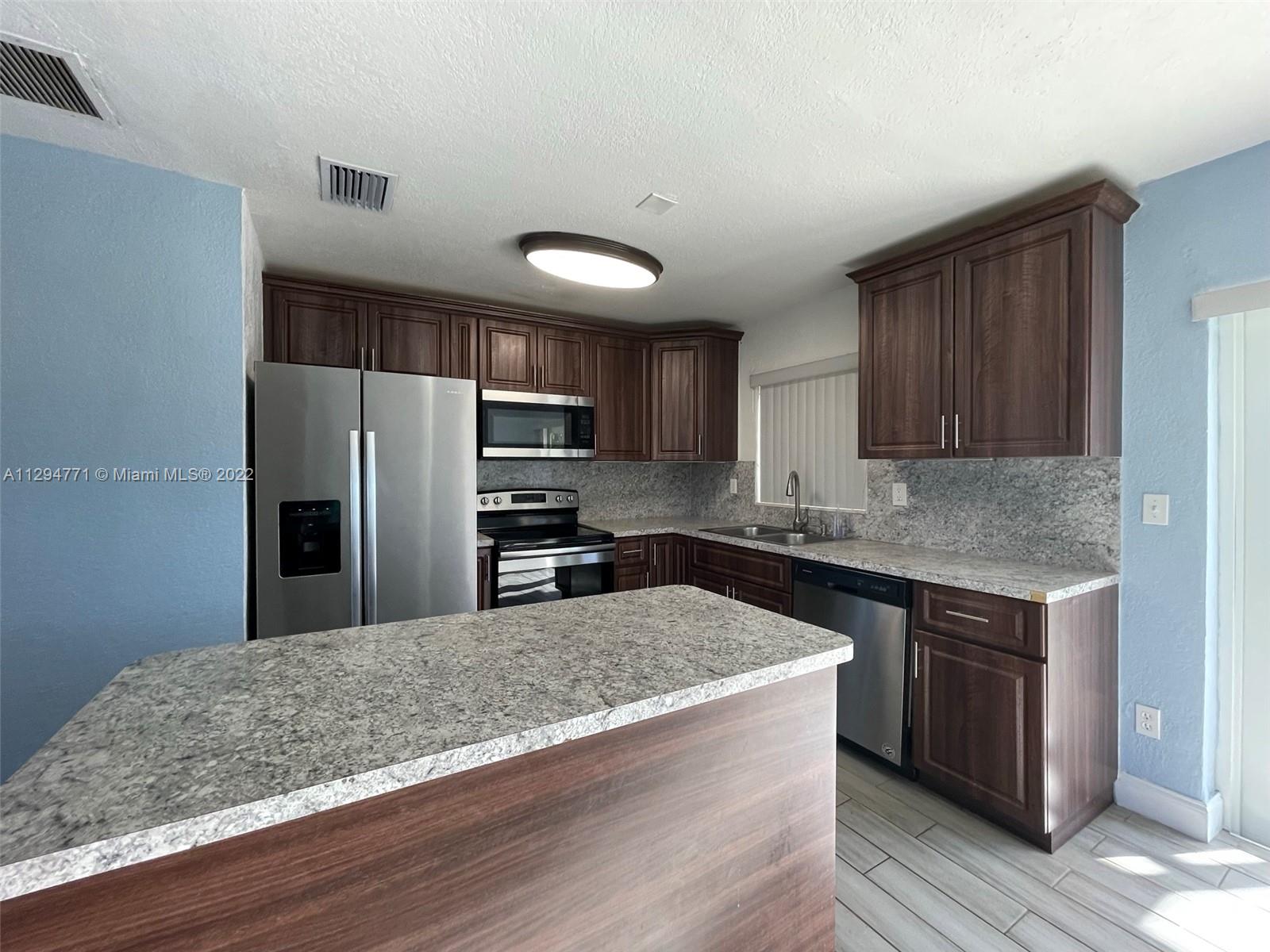 14515 Southwest 105th Court Miami, FL 33176 - Photo 6 of 30 a kitchen with stainless steel appliances granite countertop a sink a stove a refrigerator and cabinets