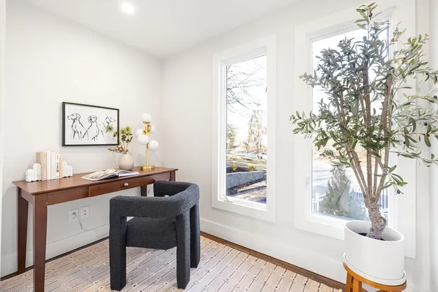 a view of a workspace with furniture and a window