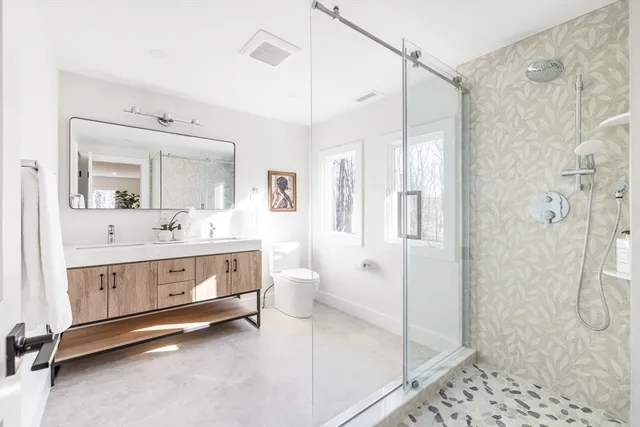 a bathroom with a double vanity sink mirror and shower