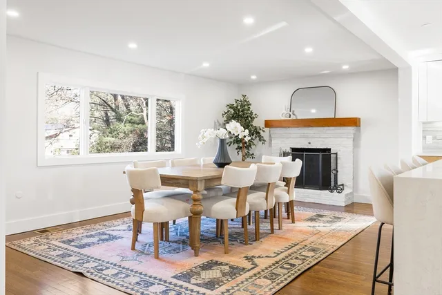 a dining room with furniture a rug and a fireplace