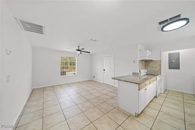 a kitchen with granite countertop a sink stove and cabinets