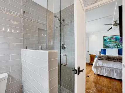 a bedroom with a bed and a flat tv screen on dresser