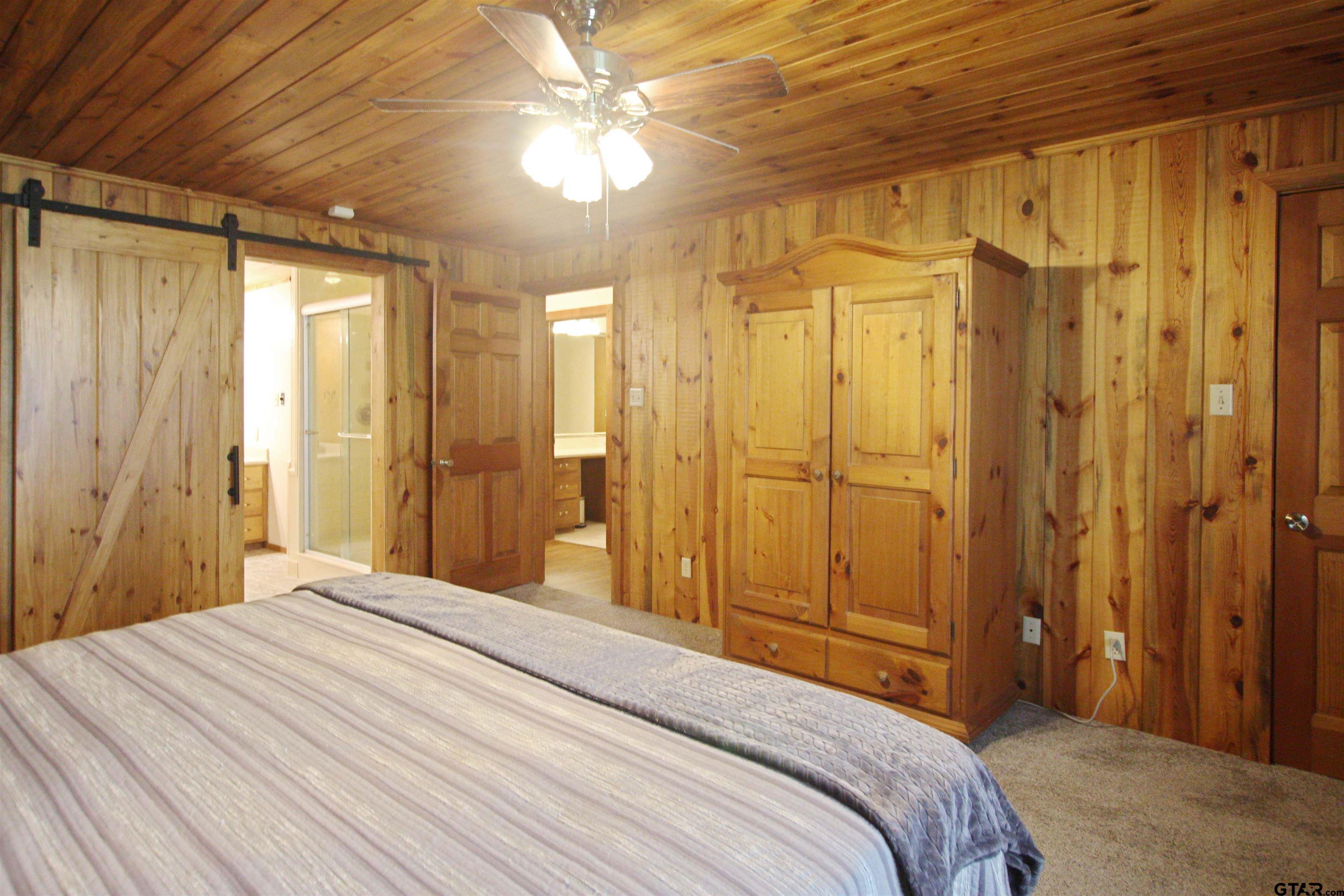 782 Rosie Wady Road Gladewater, TX 75647 - Photo 18 of 48 a bedroom with a bed and a chandelier