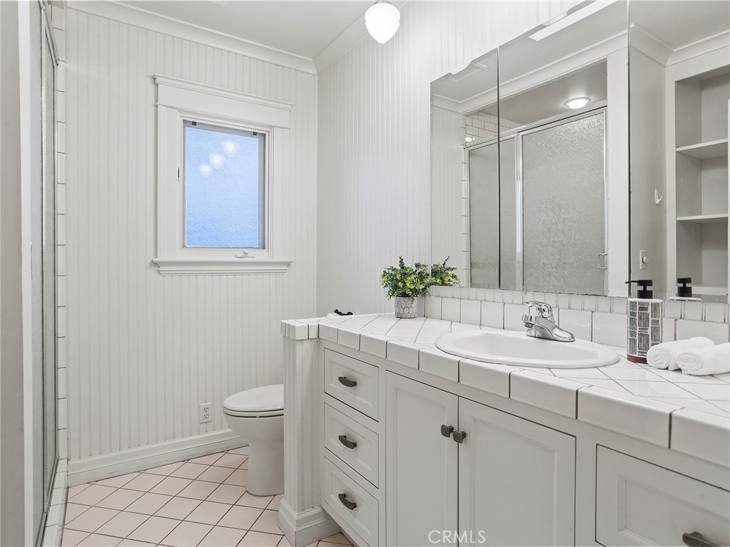 10404 Margate Street North Hollywood, CA 91601 - Photo 39 of 62 a bathroom with a toilet sink and mirror
