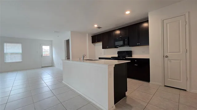 a kitchen with a sink a stove top oven and wooden cabinets