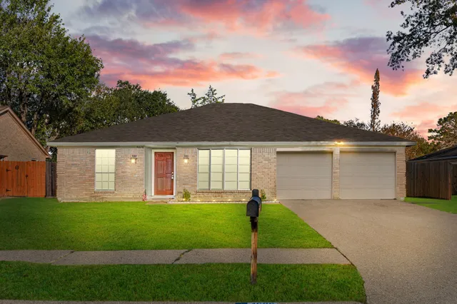 a front view of a house with a garden and yard