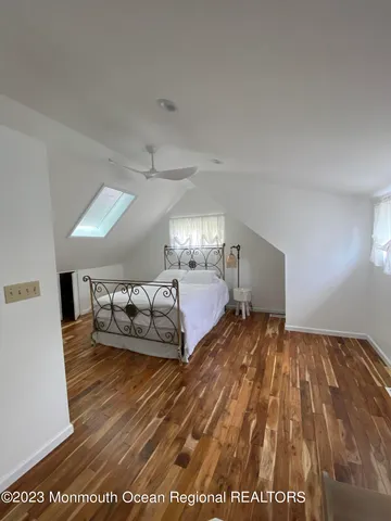 a spacious bedroom with a bed and a lamp