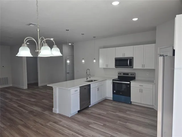 a kitchen with stainless steel appliances a stove a sink and a refrigerator