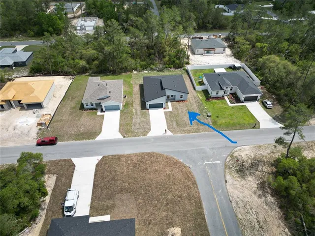 an aerial view of a house with yard and parking