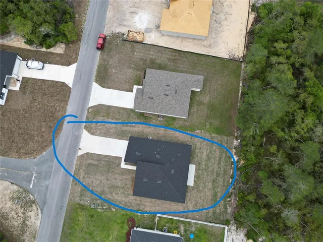 an aerial view of a house with a yard and sitting space