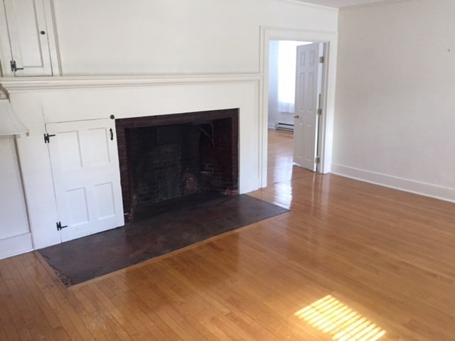 112 Main Street, Unit A Upton, MA 01568 - Photo 3 of 12 a view of a livingroom with wooden floor and a fireplace