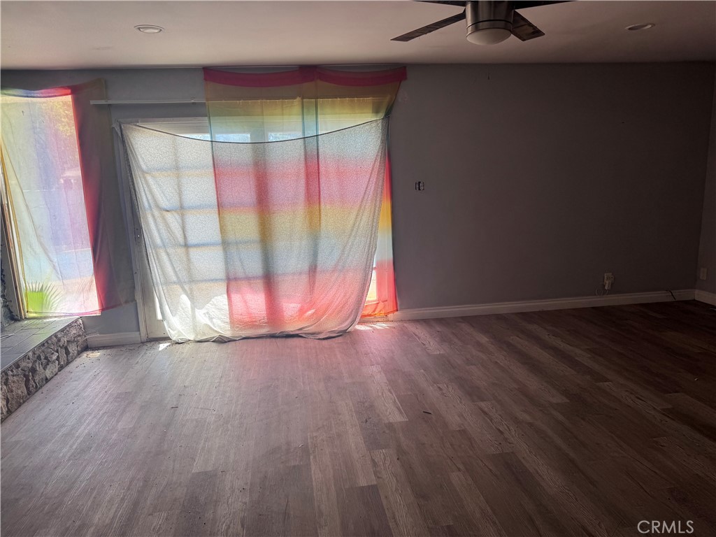 782 West Marshall Boulevard San Bernardino, CA 92405 - Photo 9 of 11 a view of an empty room with wooden floor and a window