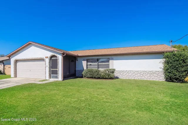 a view of a house with a yard and pathway