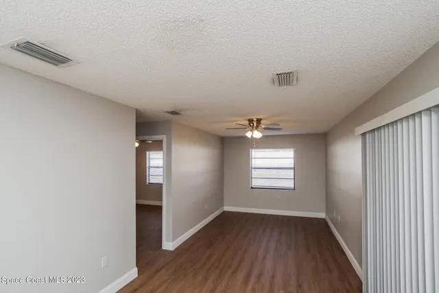 a view of empty room with window and wooden floor