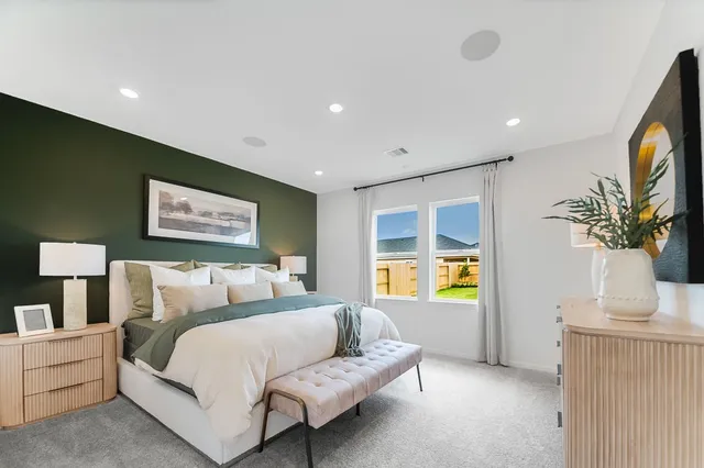 a bedroom with a large bed and wooden floor