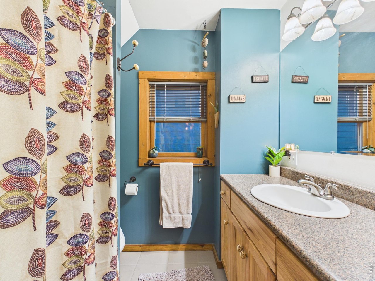 131 West Boulder Street Nederland, CO 80466 - Photo 27 of 46 Main bath with wood window, smooth countertop, designer colors, slate flooring.